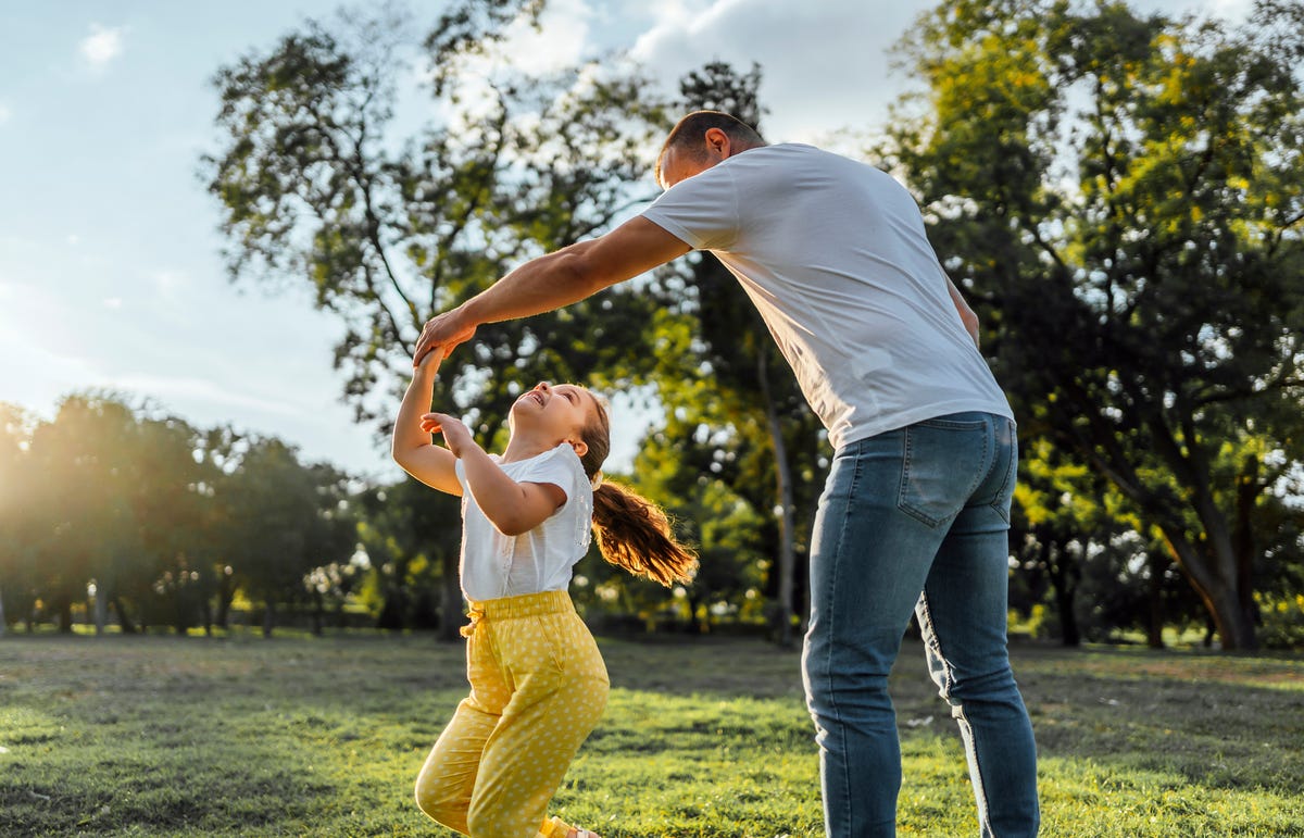 father and daughter playing together in the park