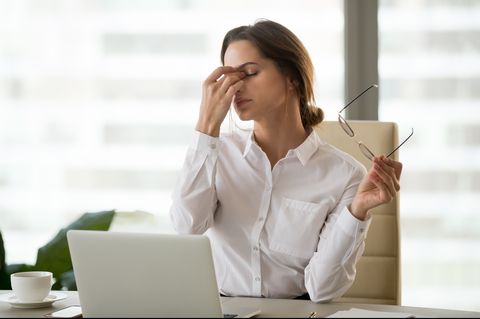 fatigued businesswoman taking off glasses tired of computer work