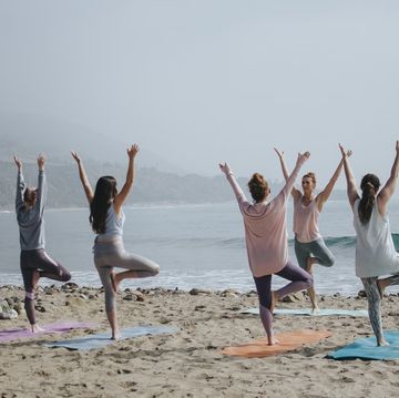 a group of women doing yoga on a beach