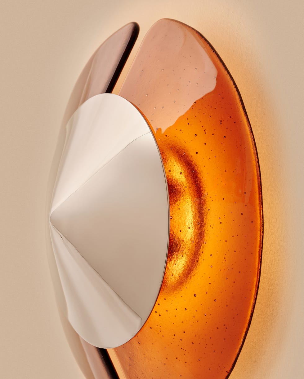 Wall-mounted decorative light fixture featuring layered glass and metal elements.