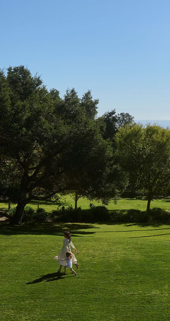 A joyful interaction between a woman and a child in a green park.