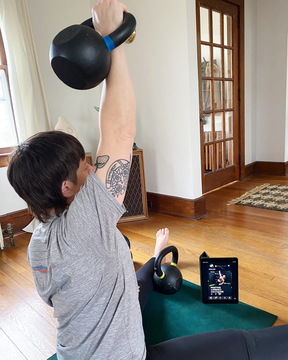 Person performing a kettlebell exercise while following an online workout person performing a kettlebell exercise while following an online workout