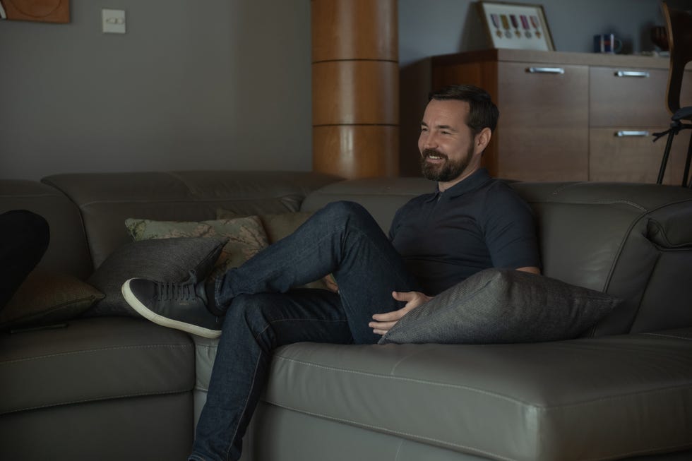 a person sitting on a modern sofa with a relaxed posture