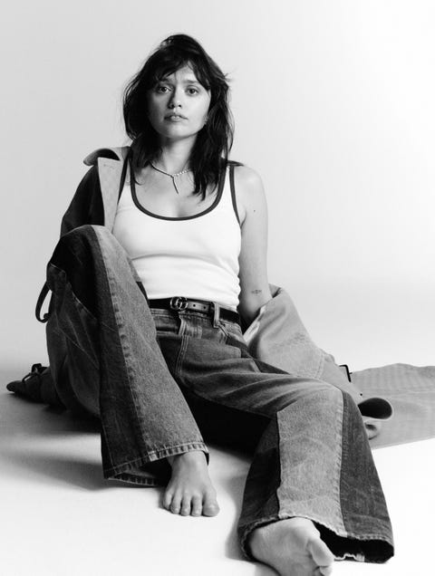 casual seated pose featuring a person wearing a tank top and wideleg jeans