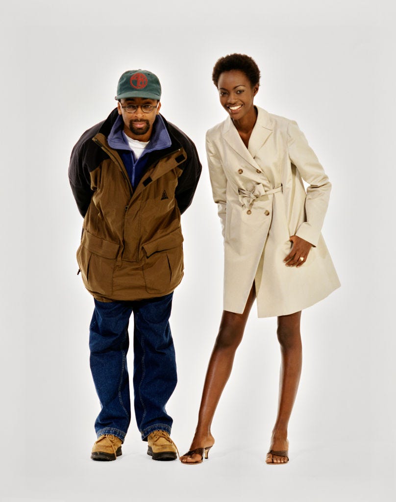 Vogue February 1996 Fashion Feature model kiara kabukuru wearing a white silk trenchcoat, by michael kors, standing next to actor and director, spike lee, smiling. (photo by arthur elgort/conde nast via getty images)