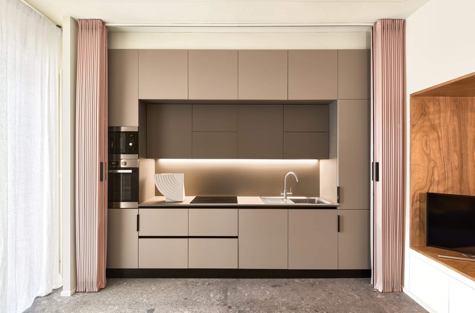 la cocina lineal se esconde detrás de una puerta corredera extensible