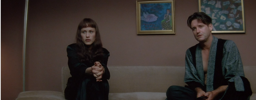 A seated couple engaged in conversation indoors.