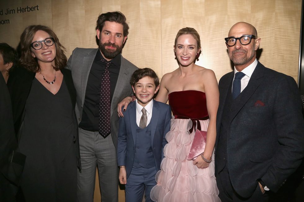 felicity blunt, john krasinski, noah jupe, emily blunt, and stanley tucci pose for a photo while standing in front of a wooden background