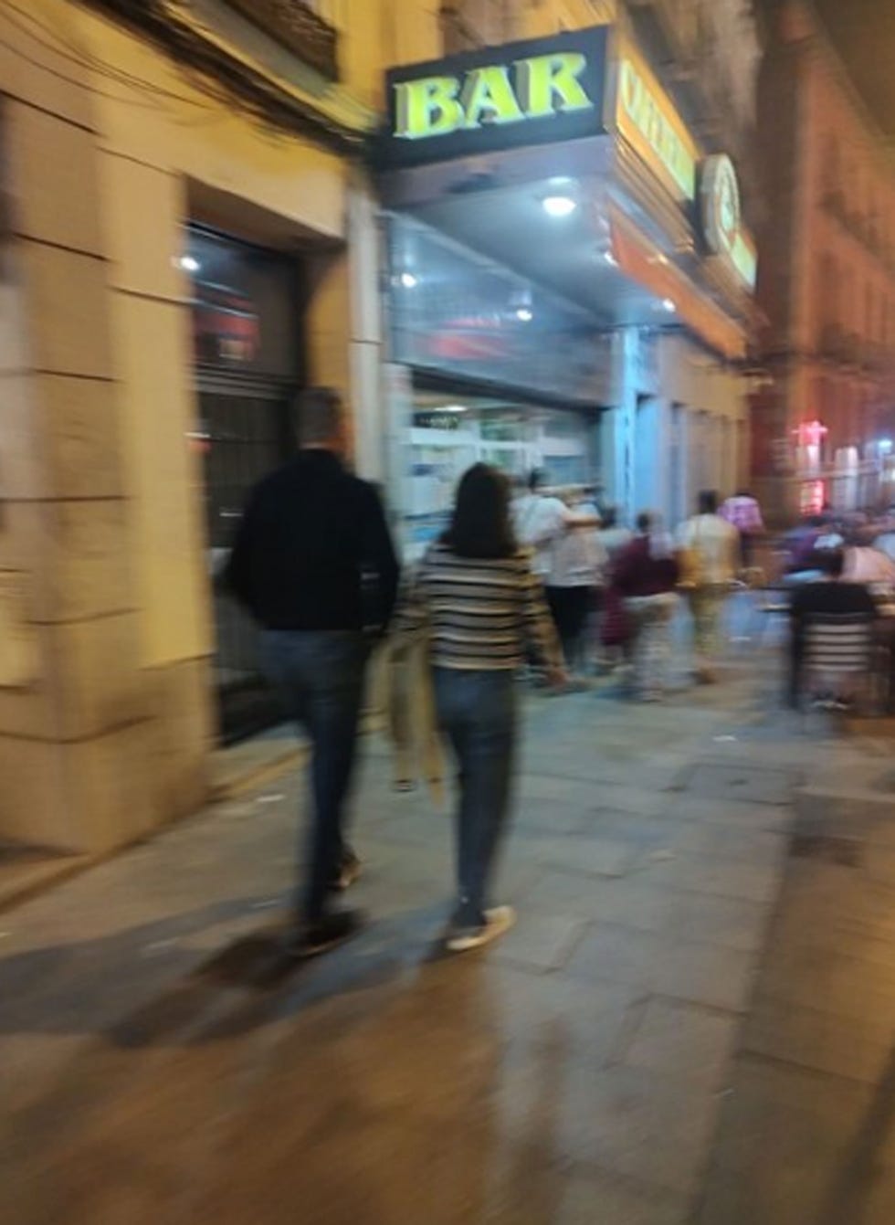 a man and woman walking down a sidewalk