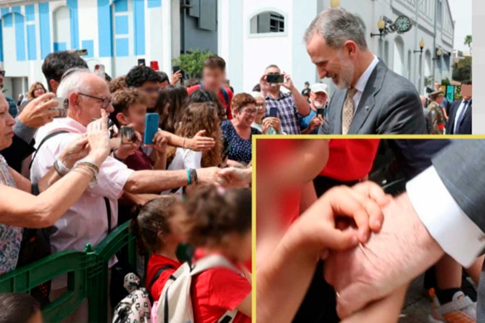 una niña pellizca la mano de felipe vi