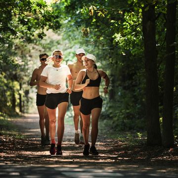 female and male pentathletes running during laser run team training for international level competition, forest