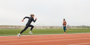 female athlete doing powerful interval running training and speed up on stadium running track