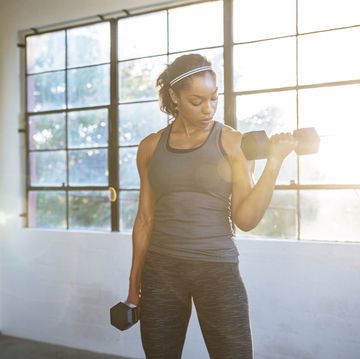 female athlete lifting dumbbells in gym