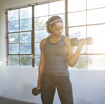 female athlete lifting dumbbells in gym