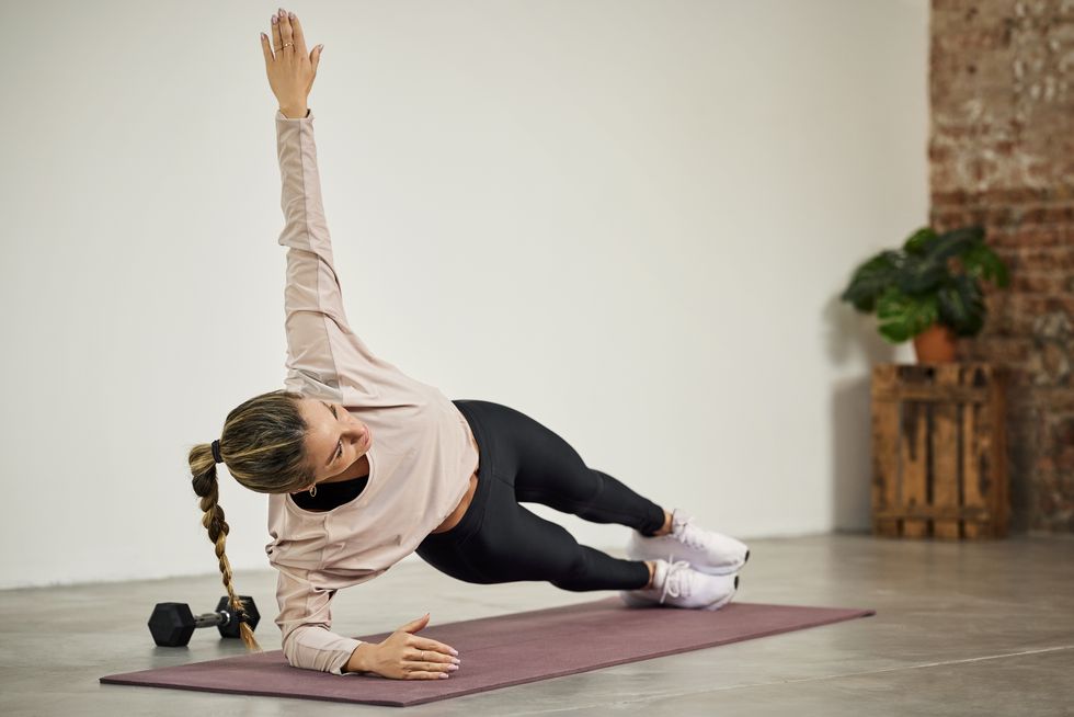 female athlete practicing side plank at home