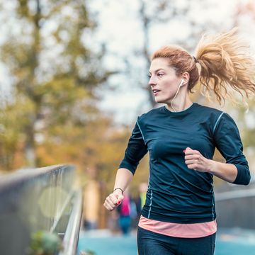 vrouw is aan het hardlopen in het park met een compressie shirt aan