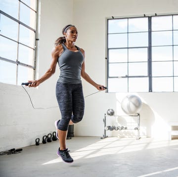 female athlete skipping with jumping rope in gym