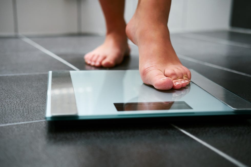 Female bare feet with weight scale