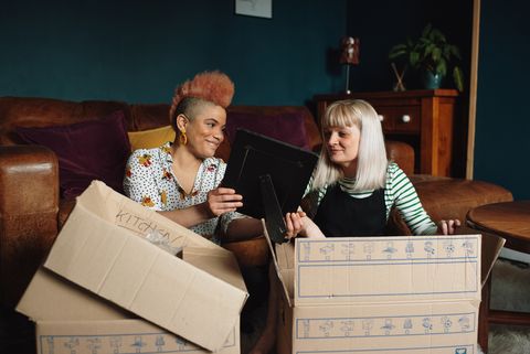 female couple unpacking boxes in new home