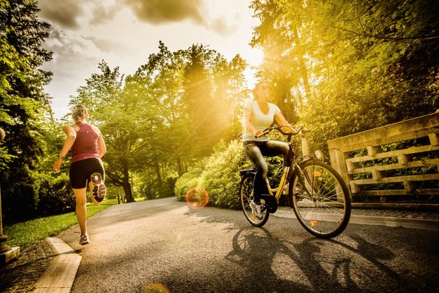 female cyclist and jogger in a park