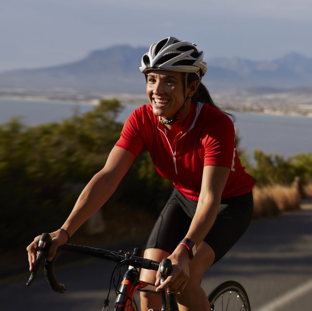 female cyclist going uphill on roadbike and laughing