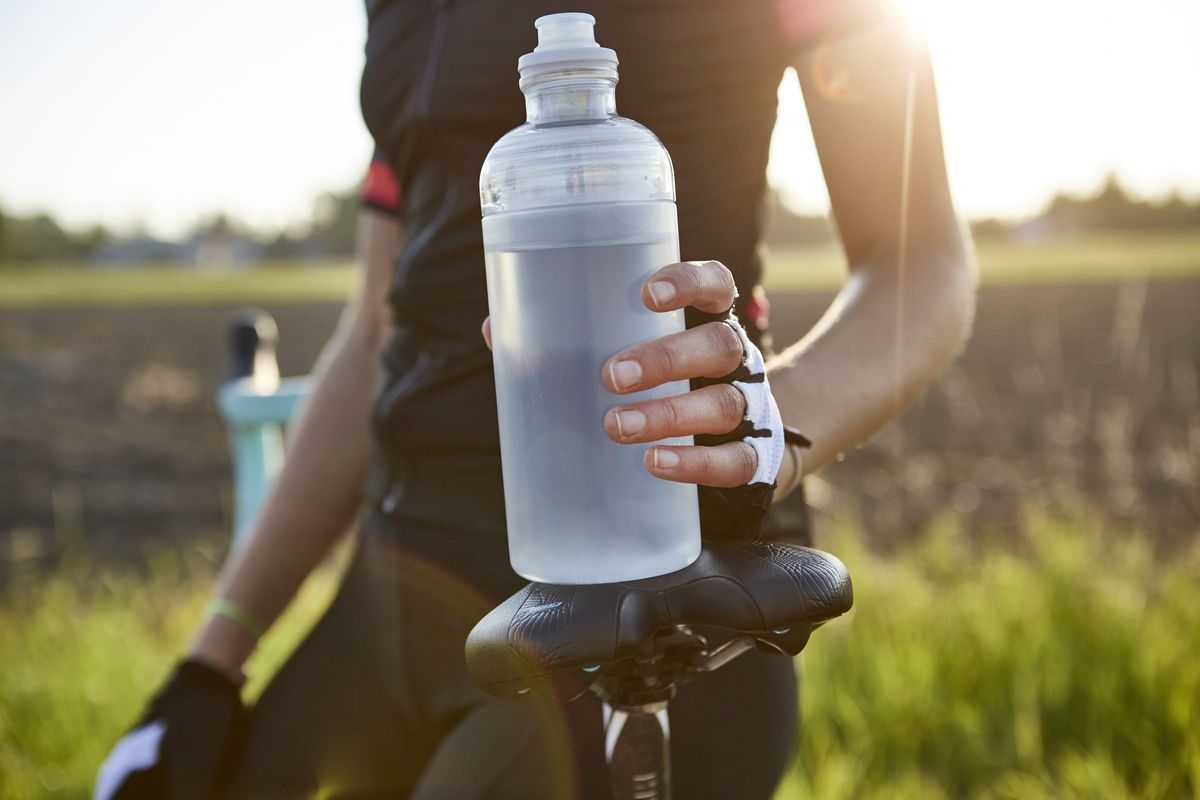female cyclist holding water bottle