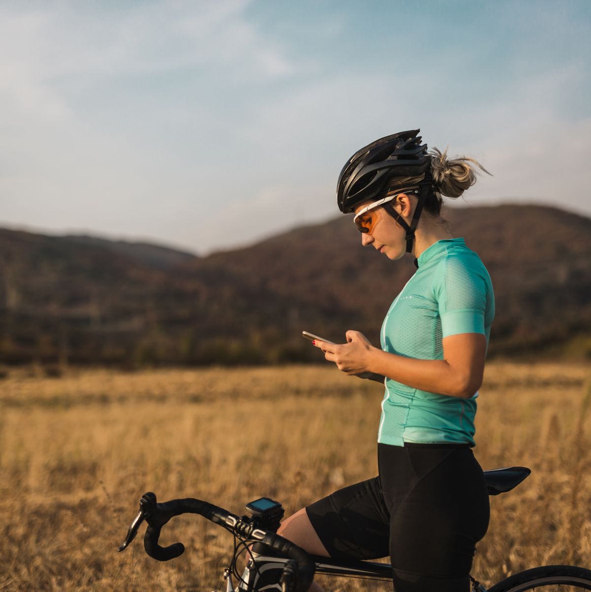 female cyclist looking gps navigation on smartphone