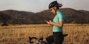 female cyclist looking gps navigation on smartphone