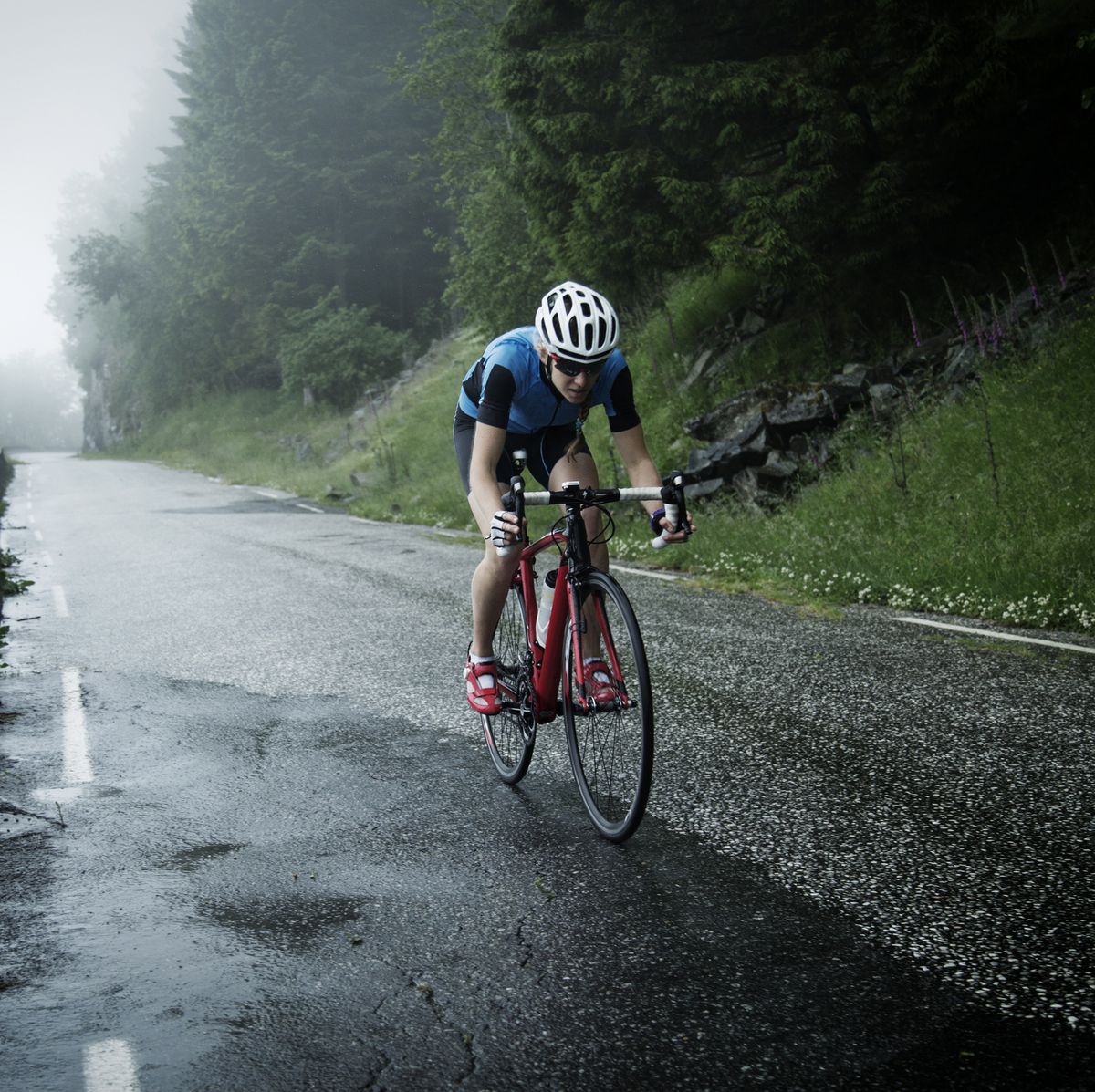 female cyclist racing down mountain road