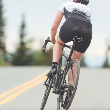 female cyclist rides along a rural highway