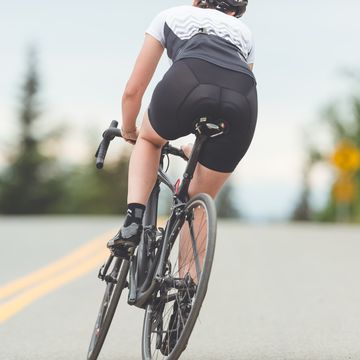 female cyclist rides along a rural highway