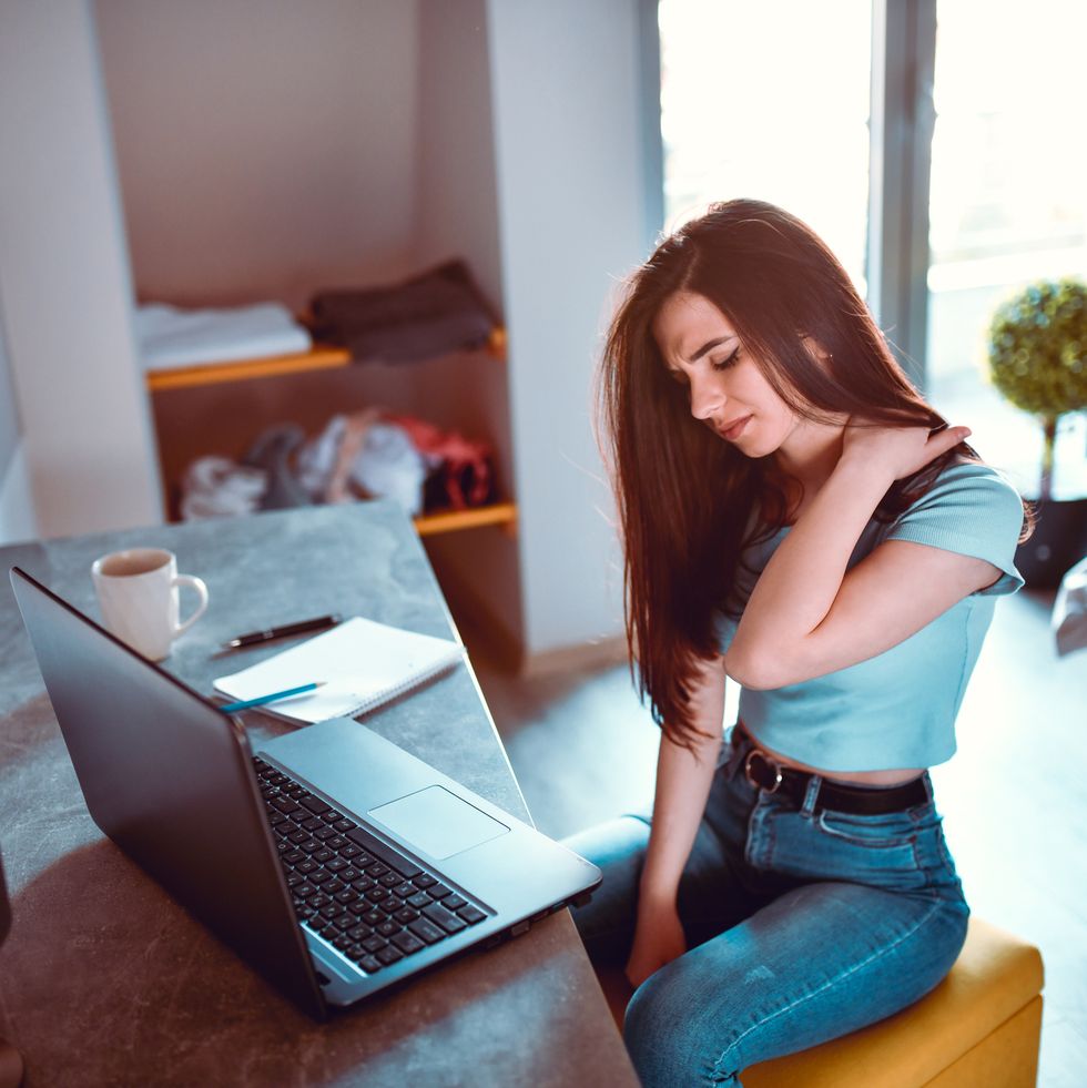 female designer experiencing neck pain and stiffness after working from home for long time