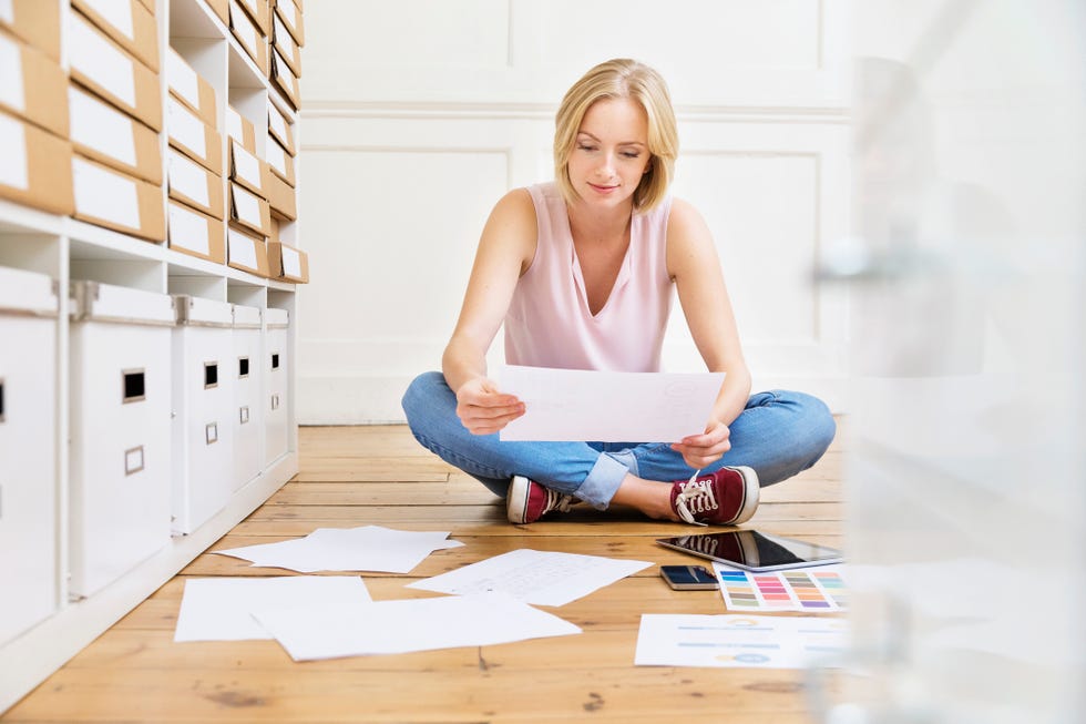 Female designer sitting on floor creating mood board in creative studio
