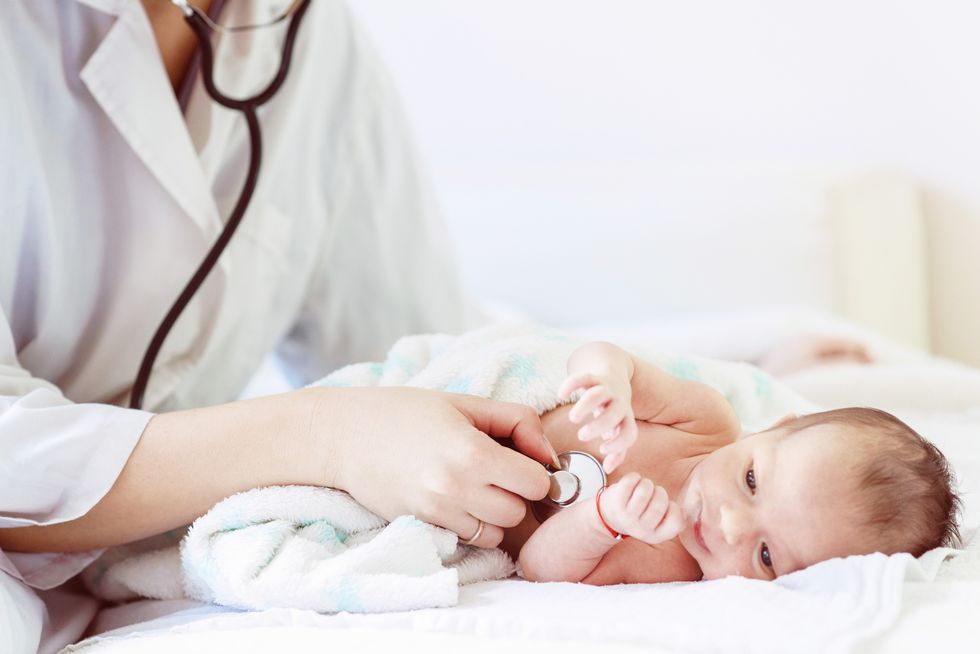 la respiración del bebé recién nacido vigilada por el pediatra en presencia de  su madre