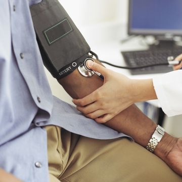 female doctor taking patient's blood pressure