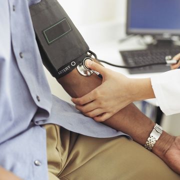 female doctor taking patient's blood pressure