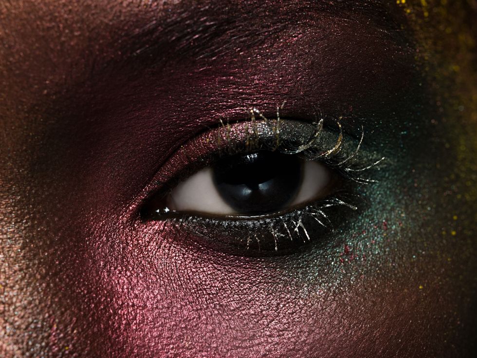 female eye covered in metallic make up