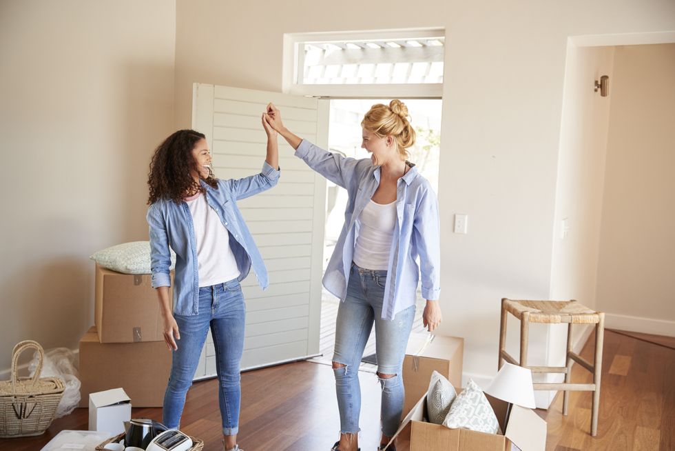 female friends celebrating in new home on moving day