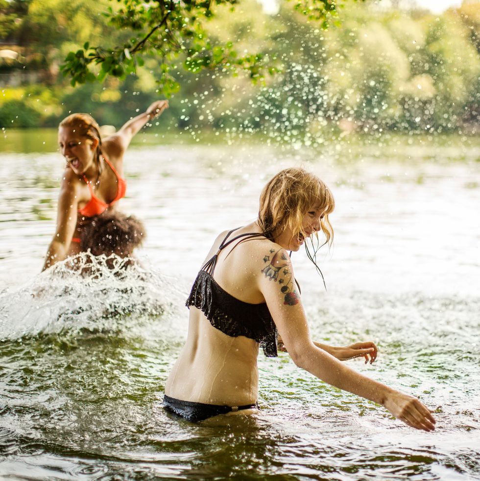 female friends having fun at lake in summer