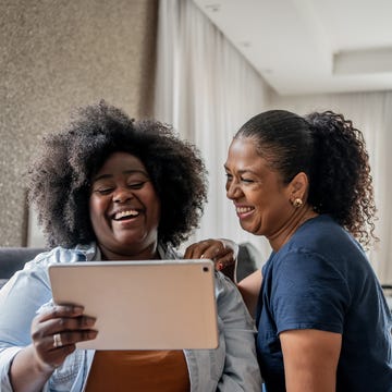 fun facts two women looking at tablet and laughing