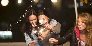 Female friends with sparklers at rooftop party