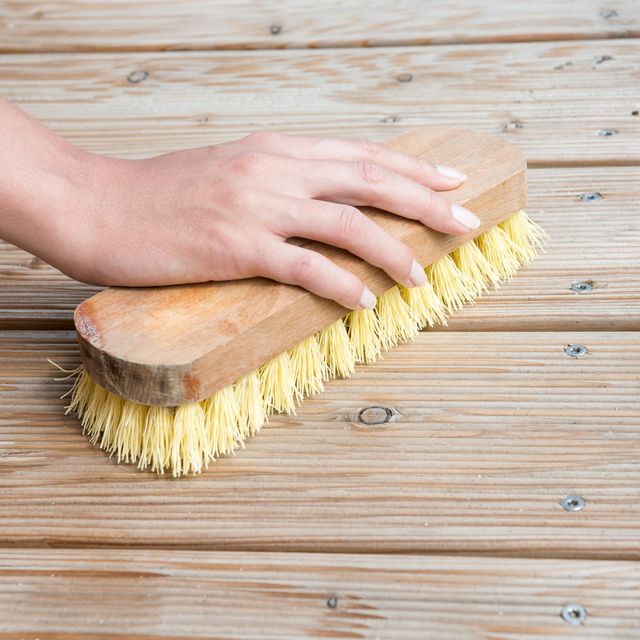 Female Hand scrubbing wooden deck