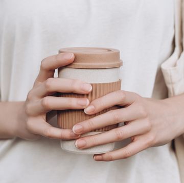 vrouw met herbruikbare koffiebeker