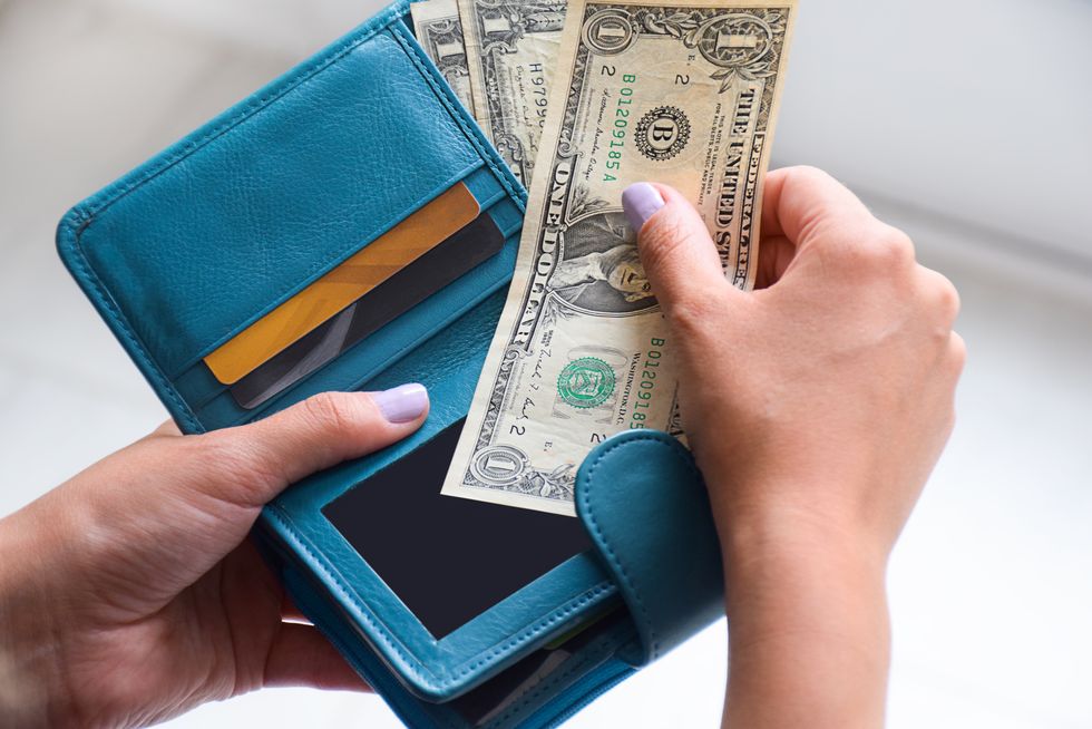 female hands holding wallet with us american cash money