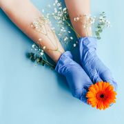 prayers for cancer  outstretched hands in medical gloves with flowers