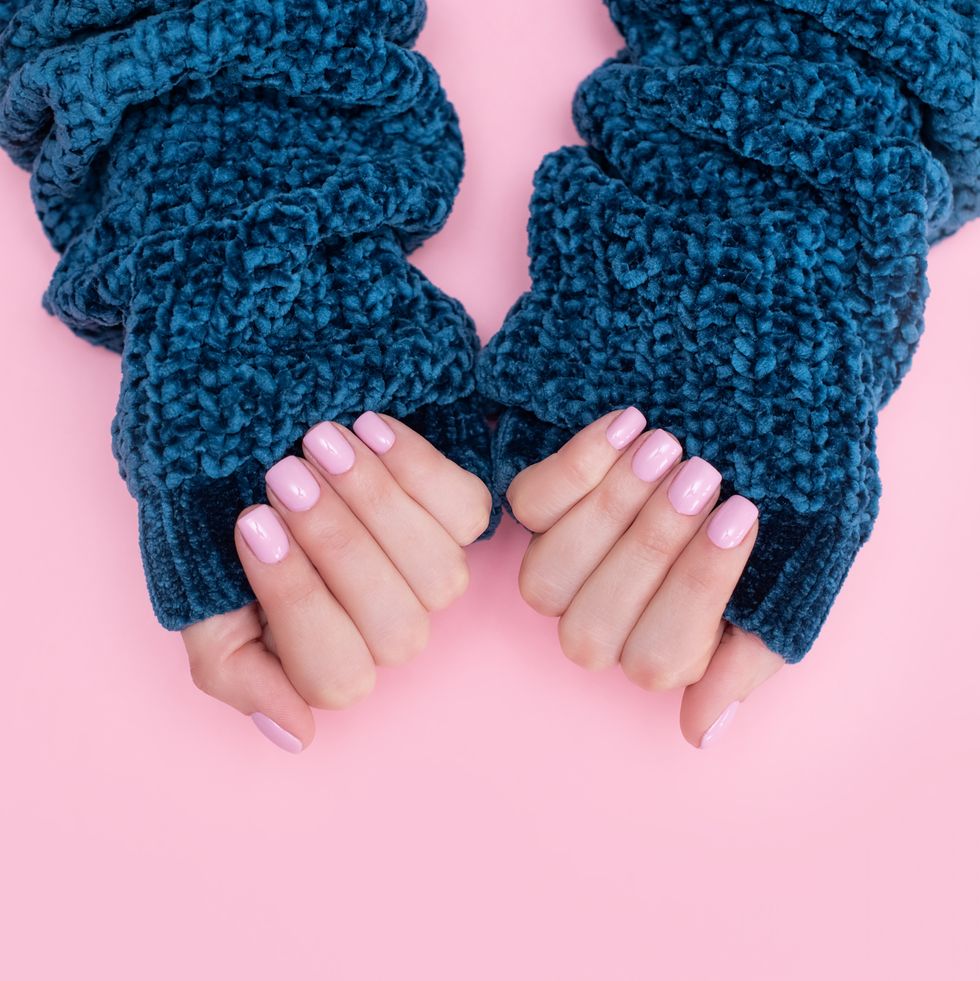 female hands manicure close up view on pink knitted sweater background nail painting effects manicure salon banner concept
