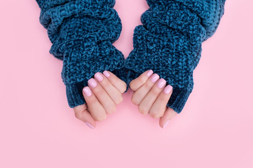 female hands manicure close up view on pink knitted sweater background nail painting effects manicure salon banner concept