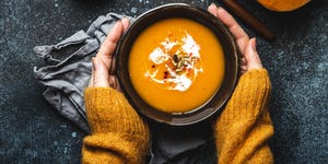 female hands with bowl of pumpkin soup