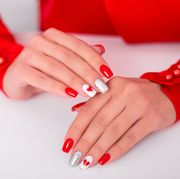 female hands with red manicure nails, hearts design