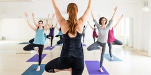 Female instructor with yoga class in the gym